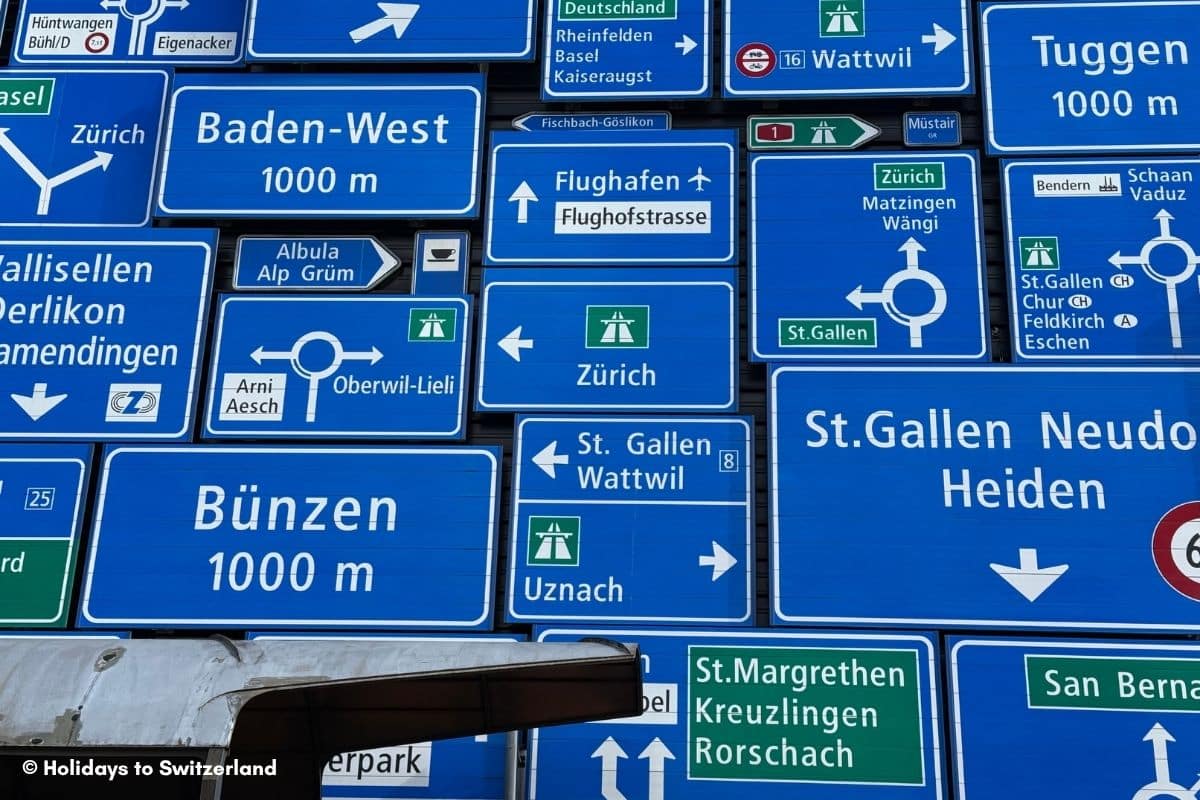 A display of road signs adorns the outside of a building at the Swiss Museum of Transport.