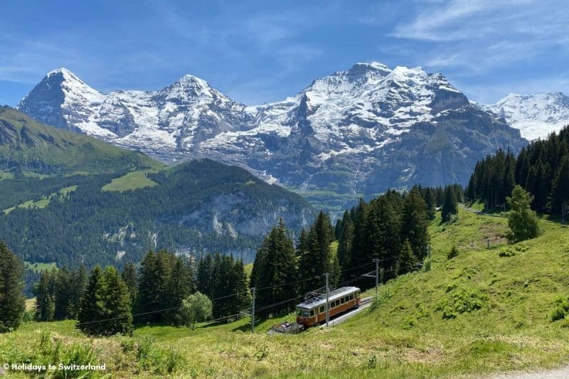 Train in front of Eiger Monch and Jungfrau mountains in Switzerland