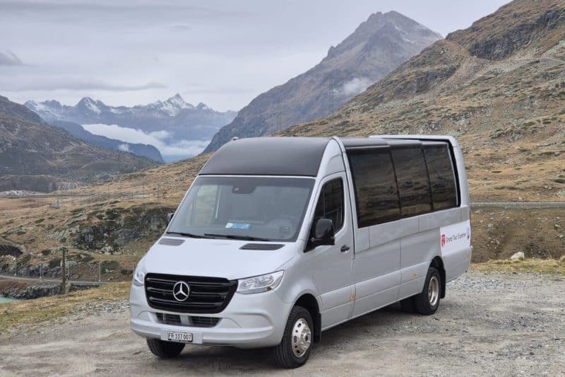 Cabrio van parked beside a road in the Swiss Alps.