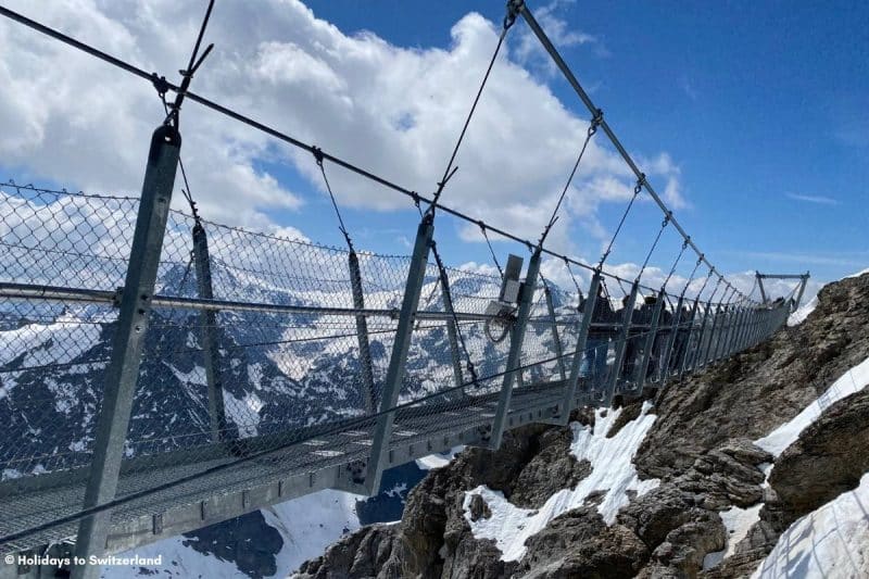 People walk across the Titlis Cliff Walk suspension bridge
